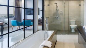 A modern bathroom with a glass-enclosed shower, a large bathtub, and a toilet. - Fox Lite Hotel Cikarang (Cikarang)