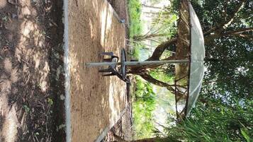 A satellite dish mounted on a metal frame, surrounded by trees and vegetation.
