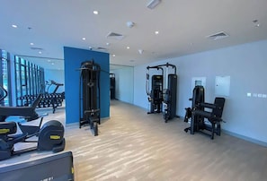 Ein modernes Fitnessstudio mit Cardiogeräten, Krafttrainingsgeräten und Kurzhanteln.