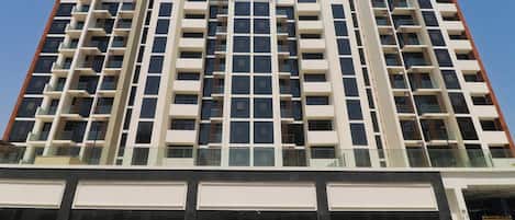 A multi-story hotel with a modern architectural design, featuring a series of balconies and large windows.