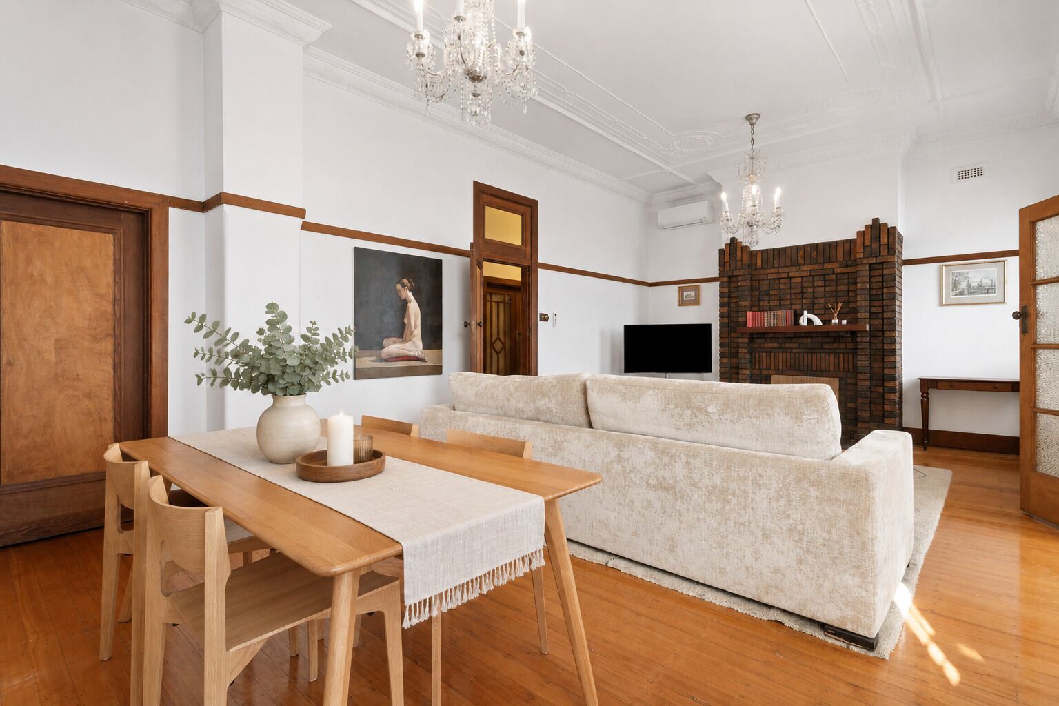 A living room with a sofa, wooden table, and a TV.