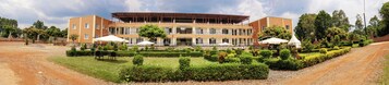 Un hotel de varios pisos con un patio central, asientos al aire libre y una zona techada.