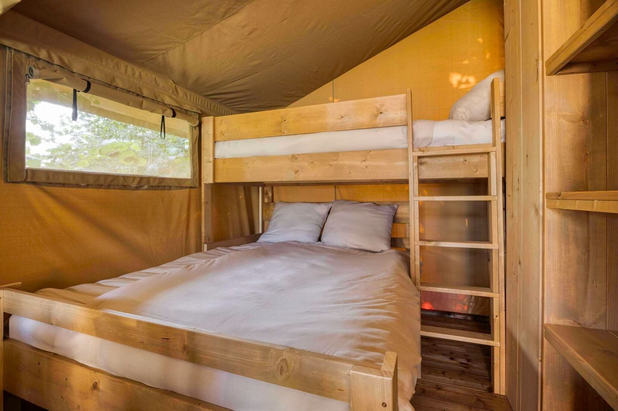 A bunk bed with a wooden frame and a window above it.