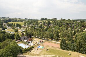 A residential area with houses, a swimming pool, and a tennis court. - Holiday Home in Grand Est (Signy-l’Abbaye)