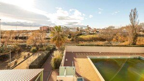 Zona de piscina en la azotea con vistas a edificios y vegetación circundantes.