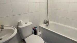 A bathroom with a toilet, sink, and bathtub. - Exquisite 1 Bedroom (Orpington)
