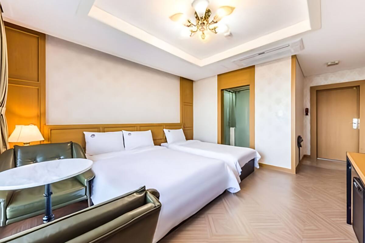 Una habitación de hotel con una cama grande, un escritorio, una silla y una mesita.