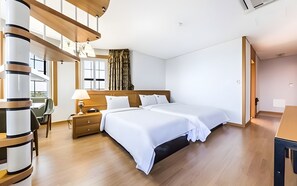 Une chambre d’hôtel moderne dotée d’un grand lit, d’un plancher en bois et offrant une vue sur l’extérieur grâce à de grandes fenêtres.