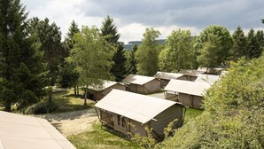 A campsite with multiple tents, surrounded by dense trees and a clear sky. - Terrace Apartment with Forest (Dochamps)