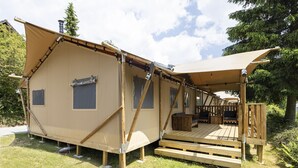 A single-story, A-frame cabin with a deck and a covered porch.