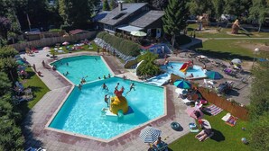 Une grande piscine extérieure dotée de plusieurs couloirs de nage, entourée de chaises longues et de parasols.