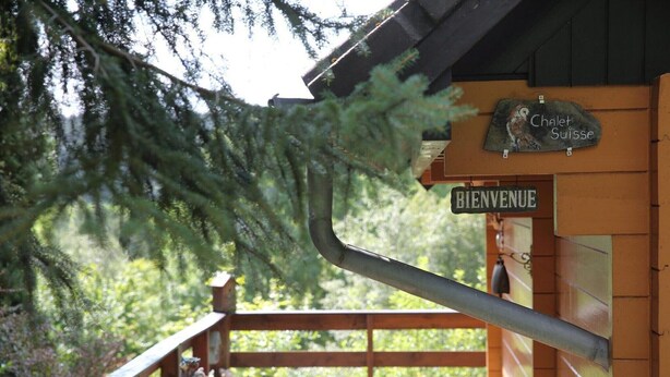 A wooden cabin with a 'Bienvenue' sign and a 'Chalet Suisse' sign. - Modern chalet in Dochamps with terrace (Dochamps)
