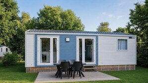 Ein Wohnmobil mit einer Terrasse, einem Tisch und Stühlen.