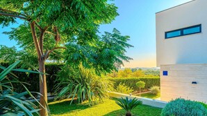 A modern building with a minimalist design, surrounded by well-maintained greenery and a clear view of the landscape.
