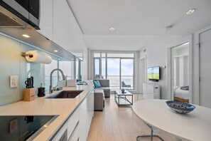 Una cucina moderna con piano cottura integrato, un'area pranzo con tavolo rotondo e un'ampia finestra che offre una vista.