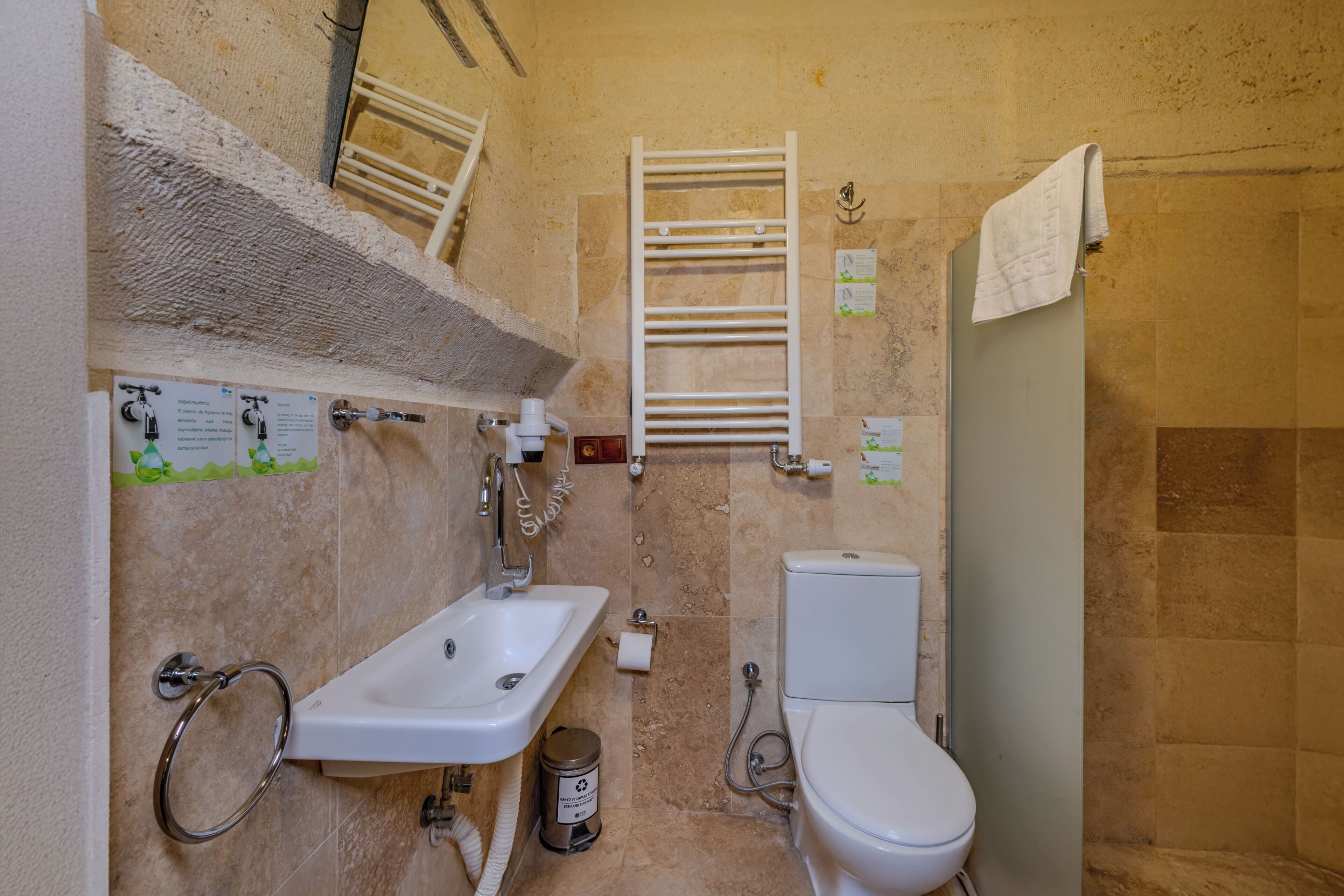 A small bathroom with a sink, toilet, and towel rack.