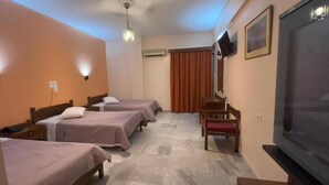 A hotel room with three single beds, a television, a desk, and a chair. - Hotel Cosmos (Athens)