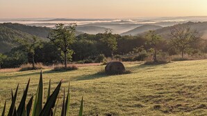 A grassy field with a hay bale and trees in the background. - DOUBLE TENTS FOR 4 PEOPLE IN THE HEART OF NATURE! Espace ERICA (Saint-Projet)