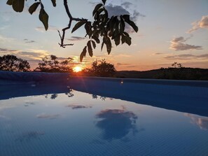 A swimming pool reflecting the sunset with a clear sky and distant hills. - DOUBLE TENTS FOR 4 PEOPLE IN THE HEART OF NATURE! Espace ERICA (Saint-Projet)
