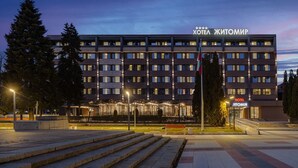 Un hotel con fachada moderna, varios pisos y una entrada bien iluminada.