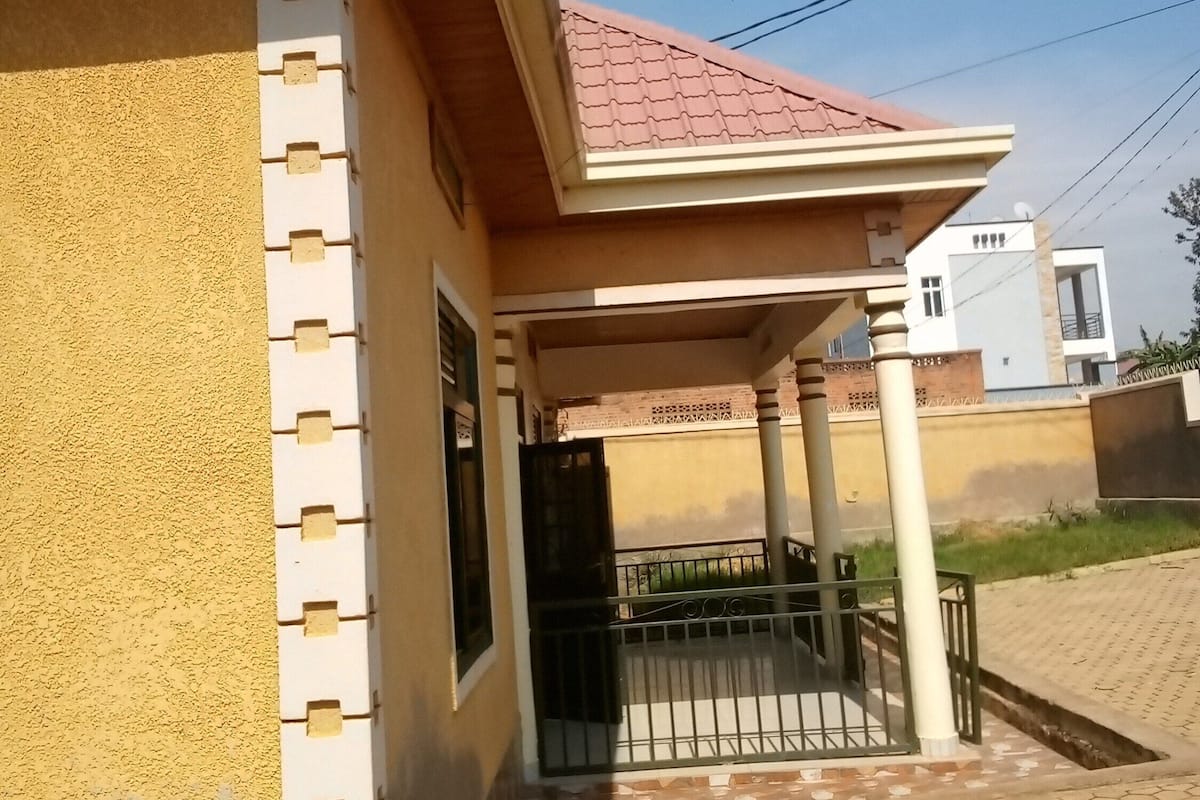 A residential building with a tiled entrance, a covered porch, and a visible door.