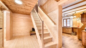 A wooden interior with a staircase, wooden walls, and a kitchen area. - Alp H tte Bregenzerwald (Schnepfau)