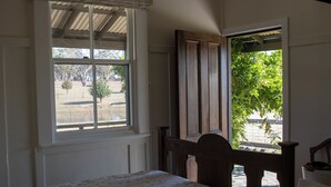 A bedroom with a bed, a window, and a view of the outdoors.