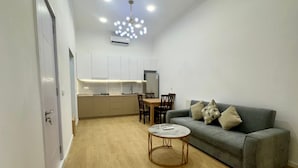 A compact living space with a kitchenette, a dining area, and a seating area with a sofa and a coffee table. - Nova Charm Aparthotel in Old Tbilisi (Tbilisi)