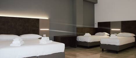 A hotel room with two beds, a large mirror, and a modern design.