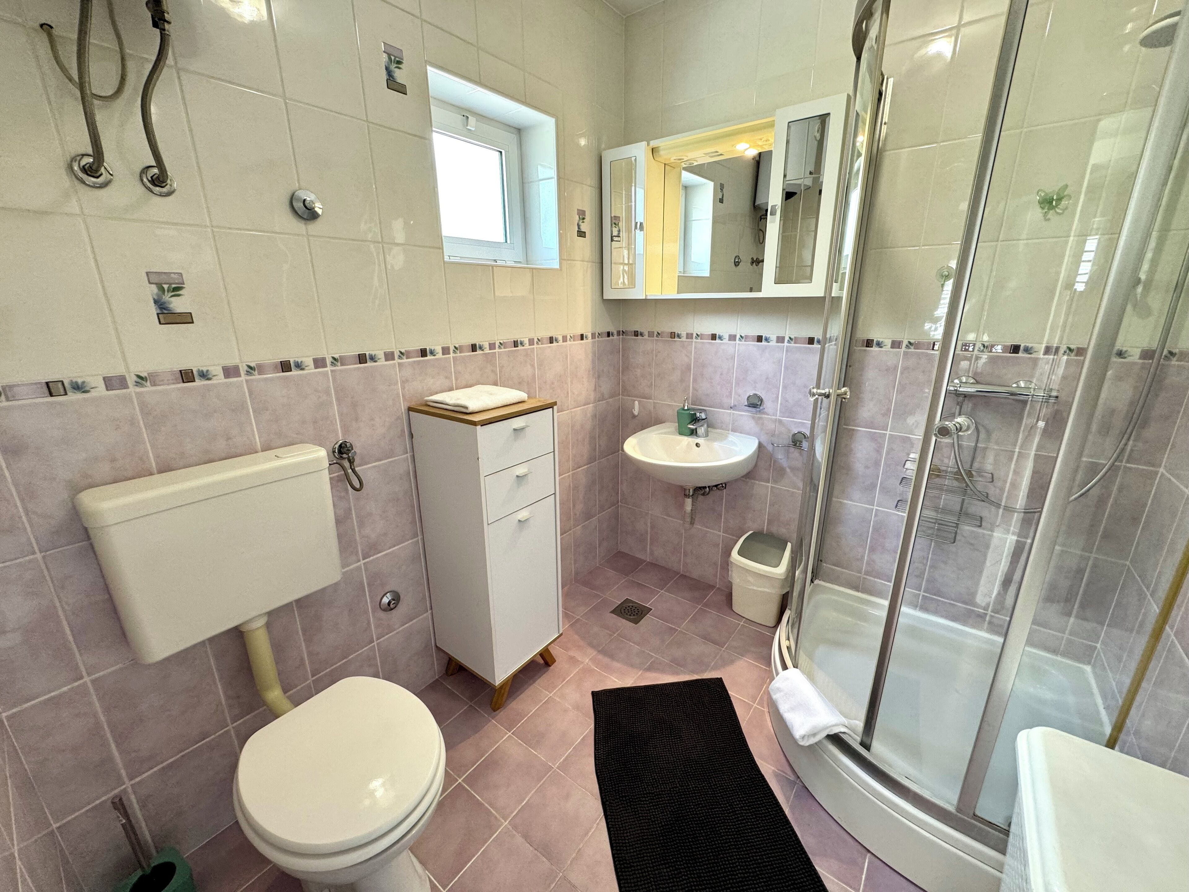 Ein Badezimmer mit Toilette, Waschbecken und Dusche.