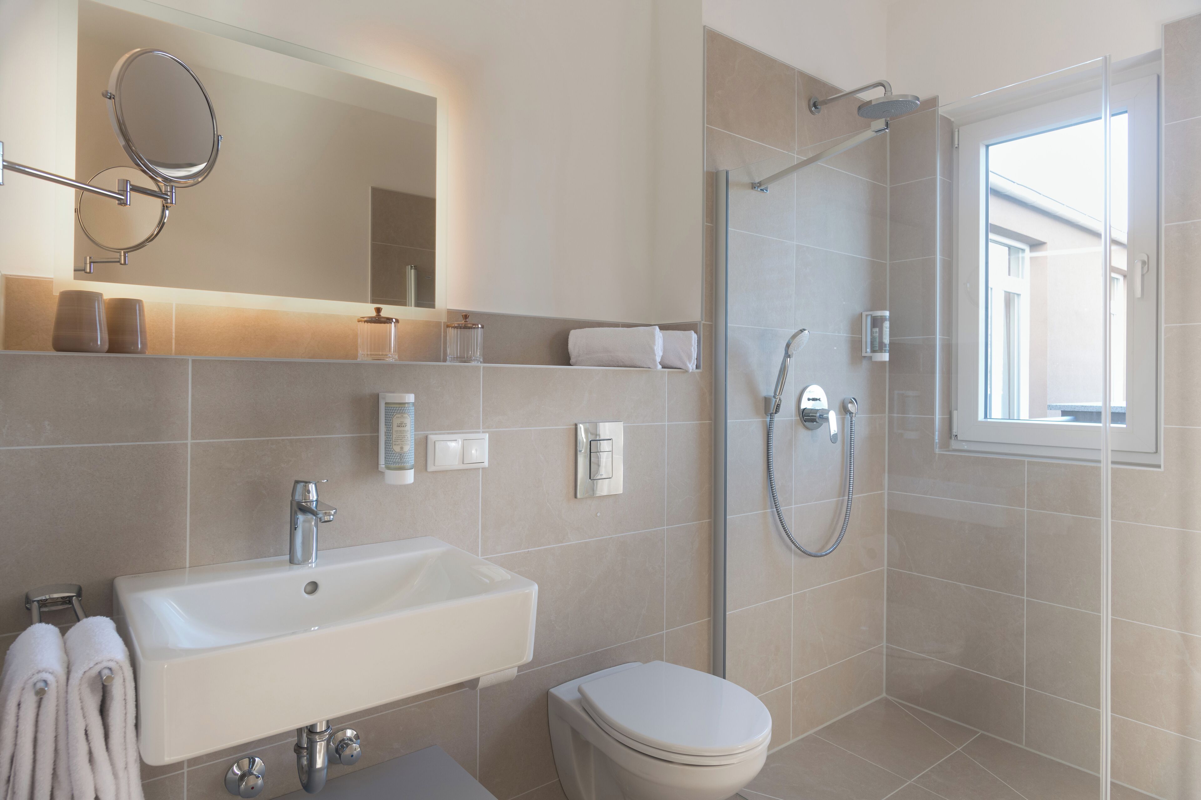 Une salle de bain moderne équipée d’un lavabo, de toilettes et d’une douche.