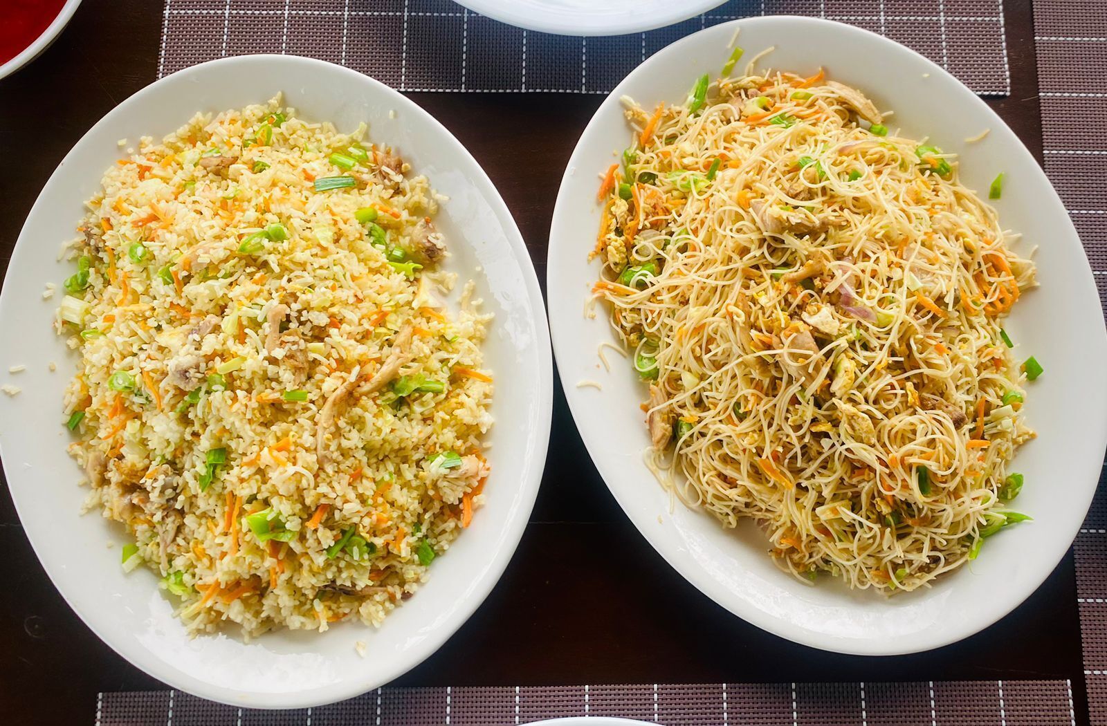 Dos tazones de arroz frito con verduras y fideos sobre una mesa.