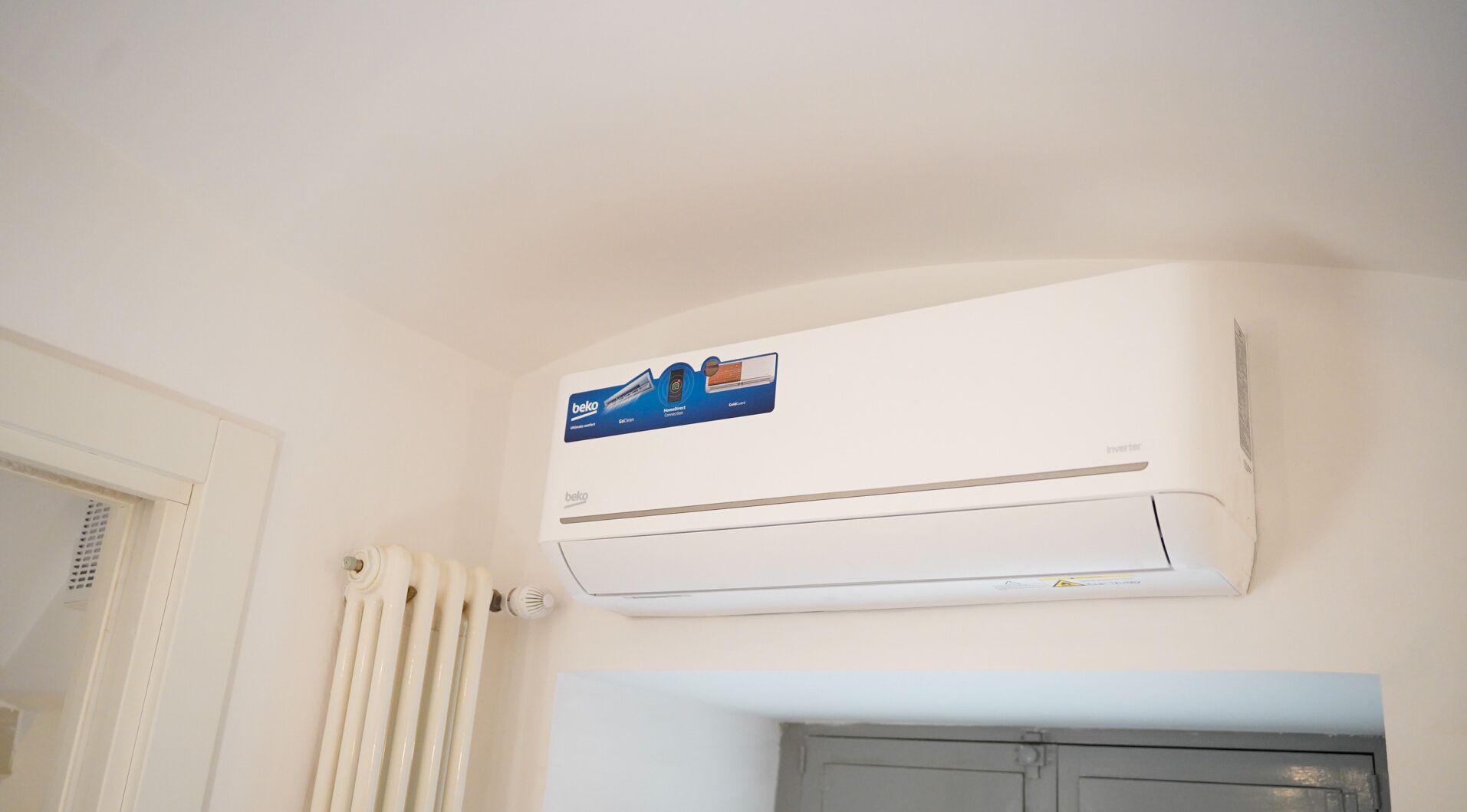Een wandairconditioner met bedieningspaneel en een logo van het merk.