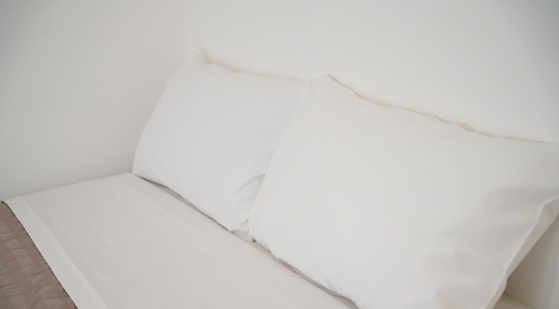 Una cama con ropa blanca y almohadas.