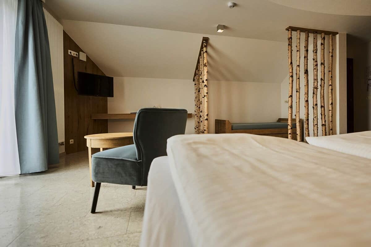 Una habitación de hotel con cama, escritorio, silla y televisor.