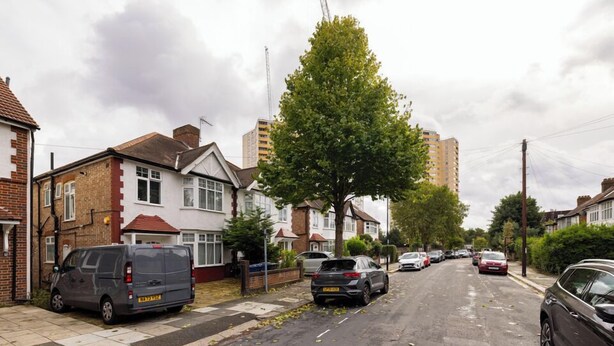 A residential street with houses, parked cars, and a tree. - Cosy Double Room in Acton (London)