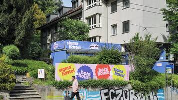 Un immeuble sur lequel est affichée une grande publicité pour « Sigma Hostel » et « Beta House ».