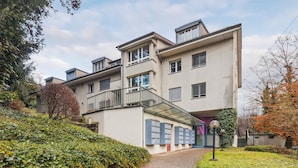 A multi-story residential building with a central staircase, a covered outdoor area, and a row of mailboxes. - Sigma Self Check-In Hostel (Zürich)