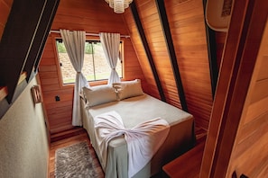 A cozy bedroom with a bed, curtains, and a wooden ceiling. - Kleines paradies chalés (Blumenau)
