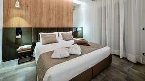 A modern hotel room with a large bed, wooden headboard, a bedside table with a lamp, and a large window with curtains. - Venice Green Residence (Mestre)