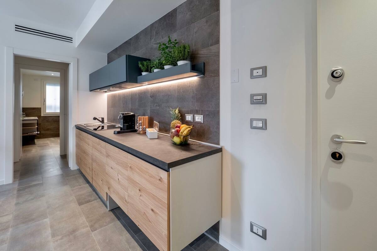 A modern kitchen with a wooden countertop, built-in appliances, and a small herb garden.
