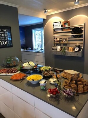 A buffet table with various food items and a wall with a motivational quote. - Aarnes House Stryn (Stryn)