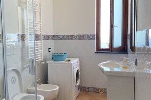 Un baño con inodoro, lavadora y lavabo.