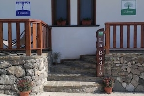 A stone staircase leading to a building with a wooden railing and a sign reading 'La Badia.'