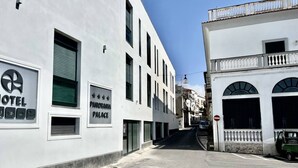 A narrow street with a white building on the left labeled 'HOTEL' and 'PANORAMA PLACE.' - Casa Nicanto – Just Steps from the Sea, Between Peace and Comfort 🌊 (Meta)