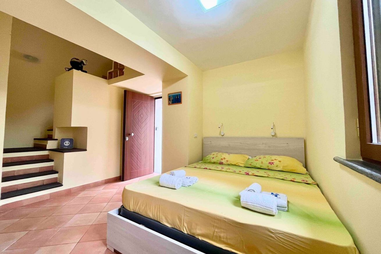 Una camera da letto con un letto, una scala, una porta e un piccolo ripiano.