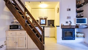 A kitchen with wooden cabinets, a microwave, a stove, and a television. - Beautiful apartment for 4 people with WIFI, TV and balcony (Madesimo)