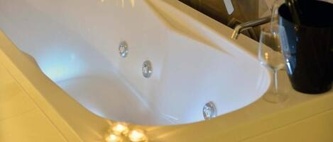 Eine Wanne mit Wasserhahn und einem Glas.