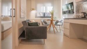 Una cocina moderna con zona de comedor, un televisor de pantalla plana y una planta en la encimera.