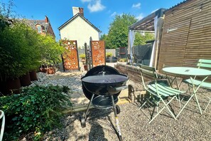 A backyard with a barbecue grill, outdoor seating, and a garden area. - Derbe House, Derbe Road (Lytham St Annes)